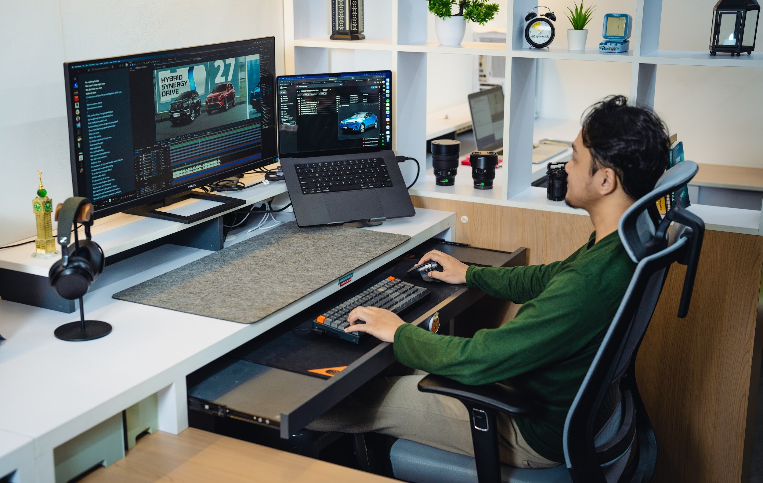 Editor video menyunting rekaman di meja kerja dengan dua monitor