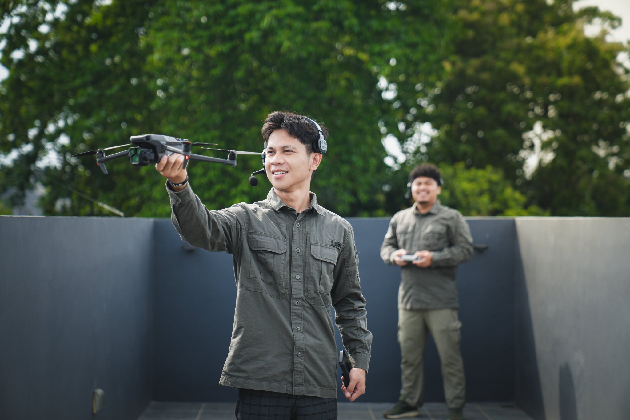 Pilot drone menerbangkan drone dengan remote control di area terbuka